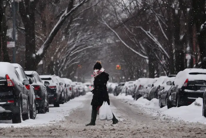 Woman crosses the street in Park Slope on a snowy day.